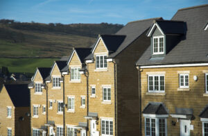 new build beige brick homes with hill in background