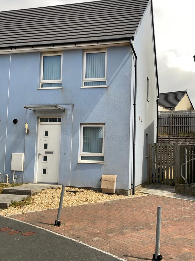 An external photo of a house. The home is painted a light blue, with a white front door.